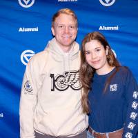 Young man and woman posing for photo in front of GVSU backdrop